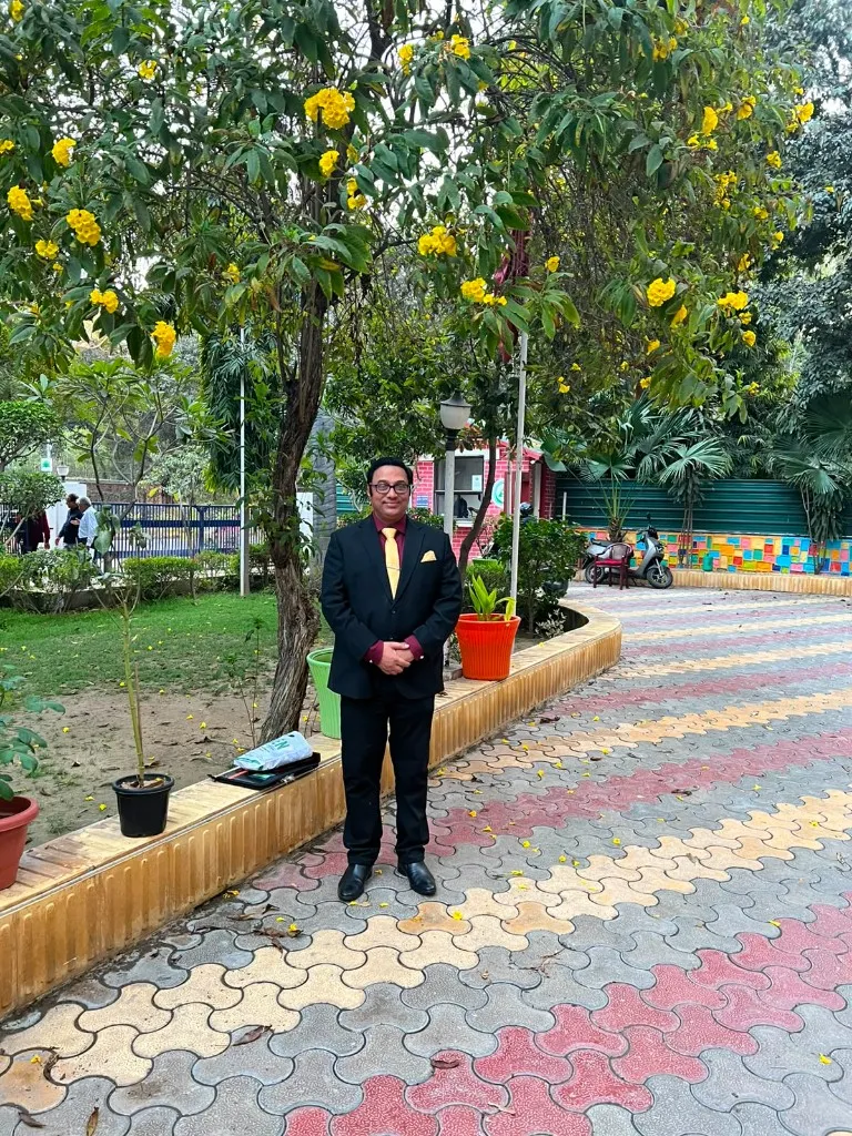 Dr. Anuj Kumar standing in a garden setting during a professional visit